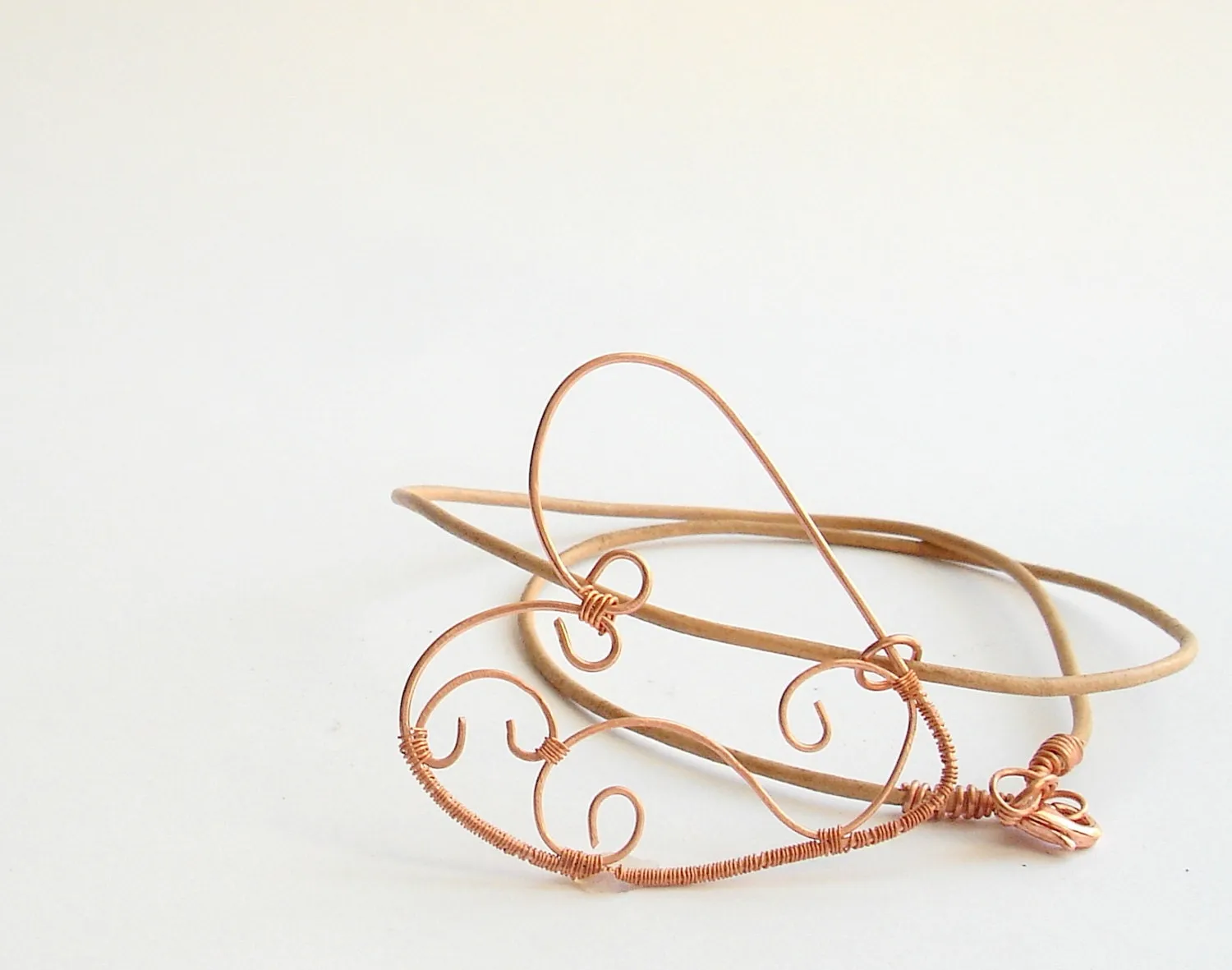 Copper wire wrapped heart pendant with natural leather string.