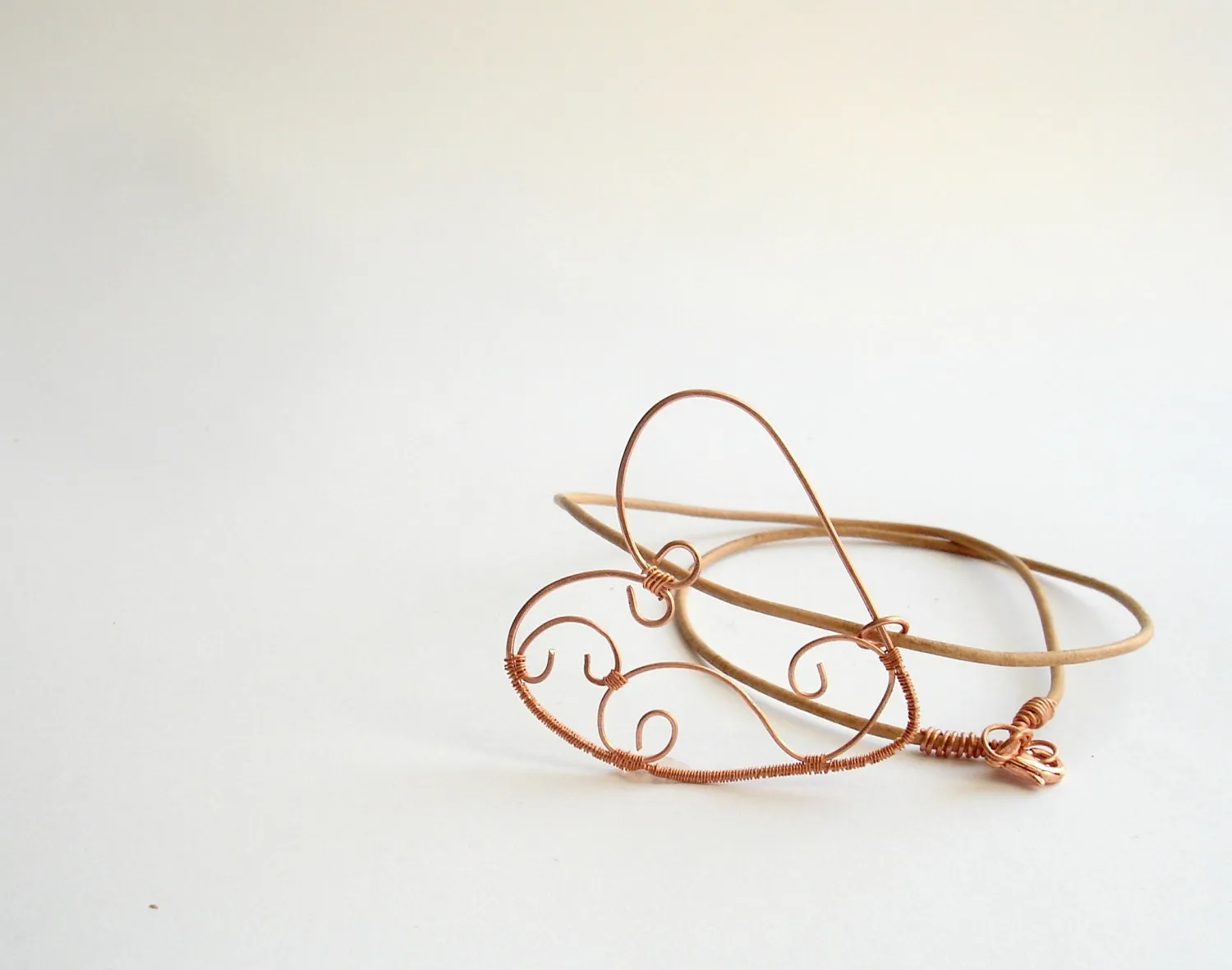 Copper wire wrapped heart pendant with natural leather string.